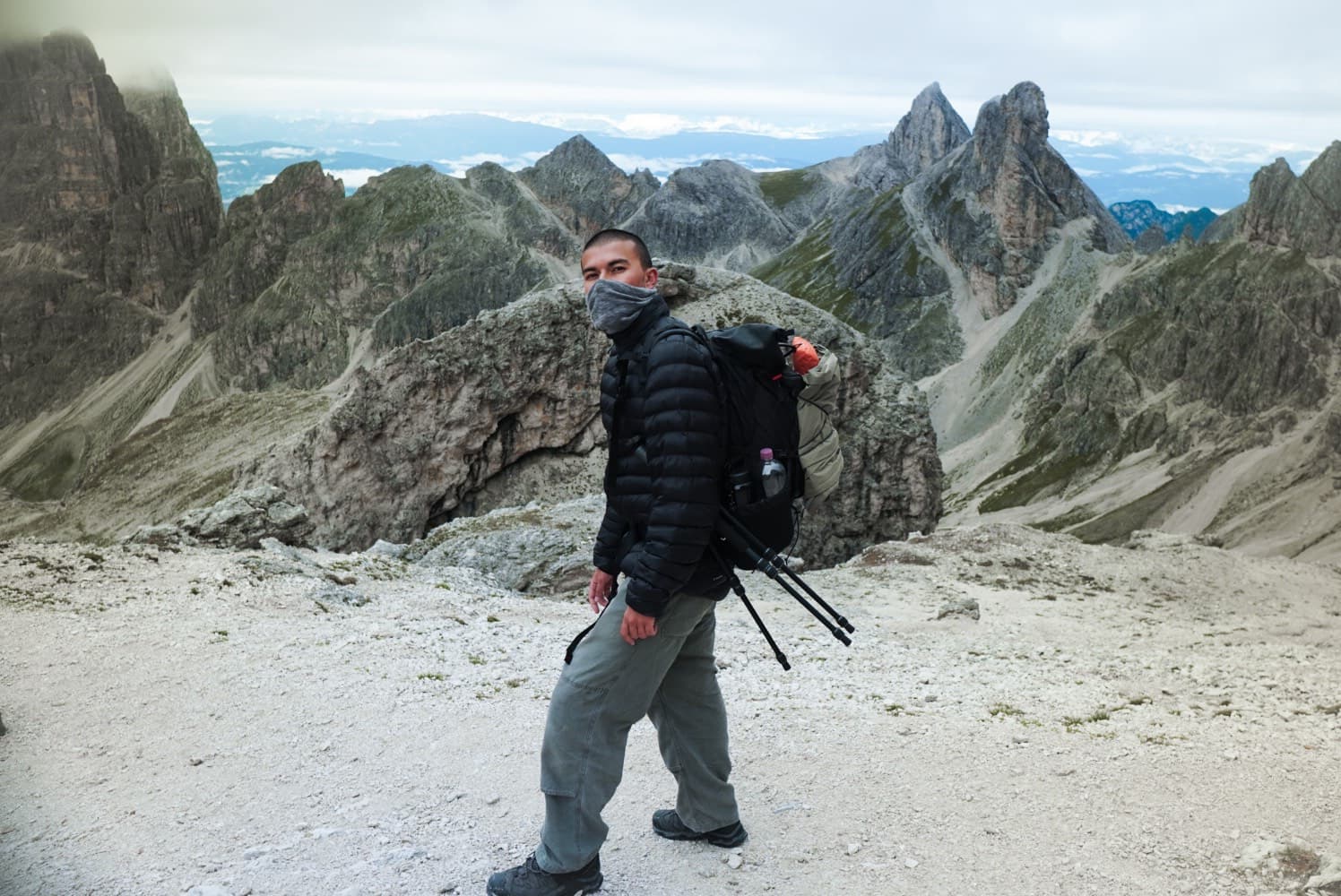 Arman Parsa hiking in the Dolomites, carrying a camera pack and tripod