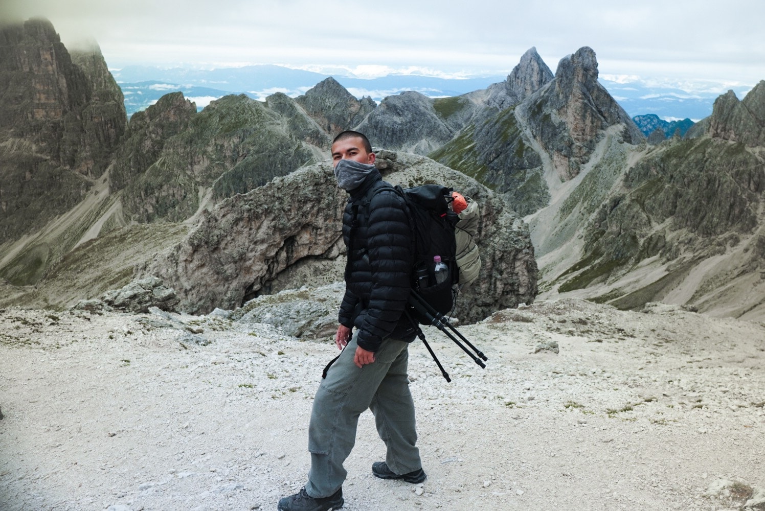 Arman Parsa hiking in the Dolomites, carrying a camera pack and tripod